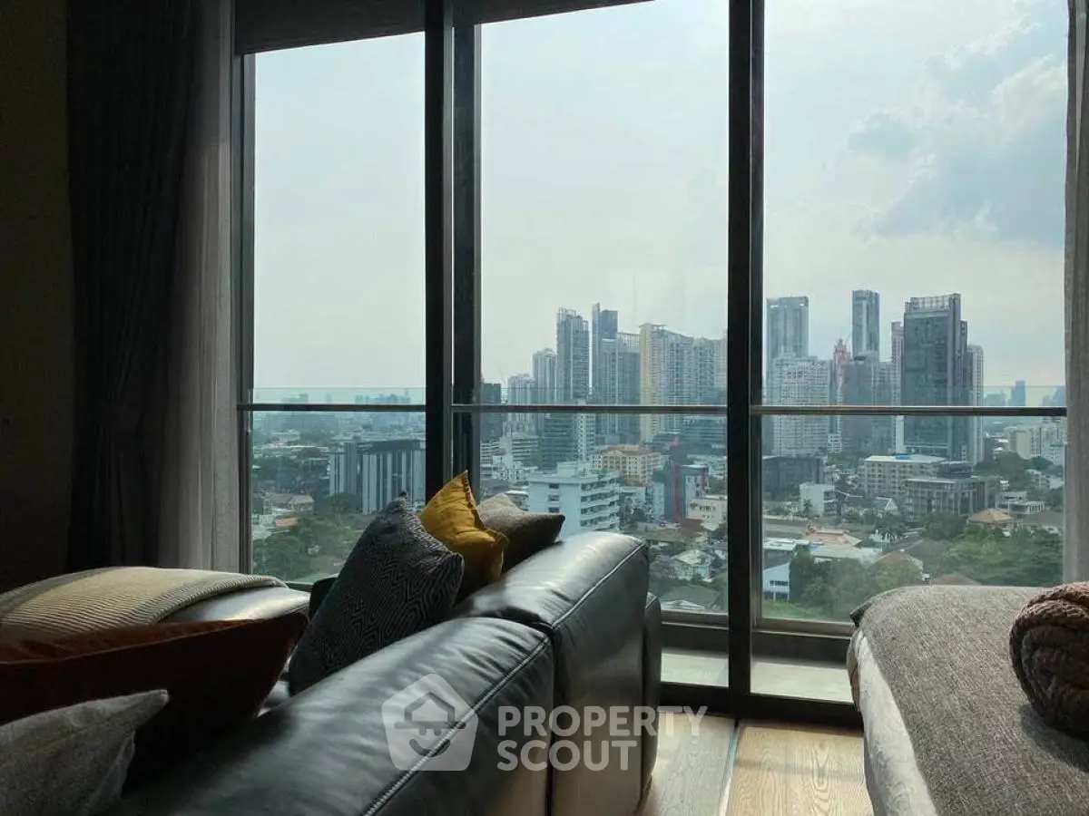 Luxurious living room with stunning city skyline view from high-rise apartment.