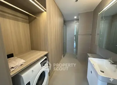 Modern bathroom with washing machine and sleek wooden cabinetry