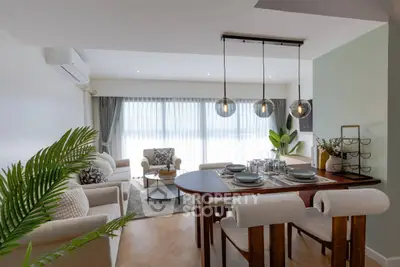Spacious modern living room with dining area, elegant decor, and large windows for natural light.