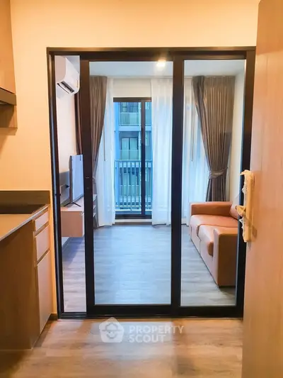 Modern apartment with open layout, featuring a cozy living room and kitchen area, perfect for urban living.