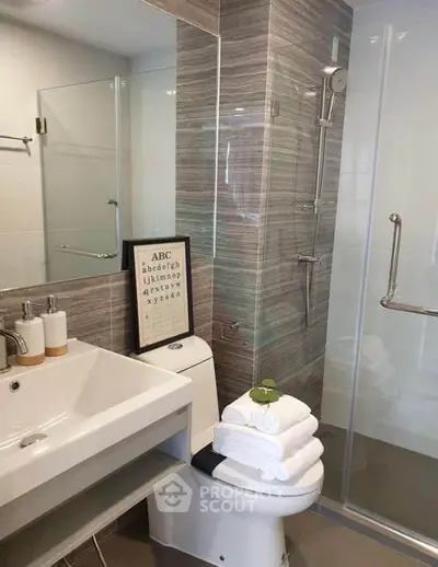 Modern bathroom with sleek shower, stylish sink, and elegant decor in a contemporary home.