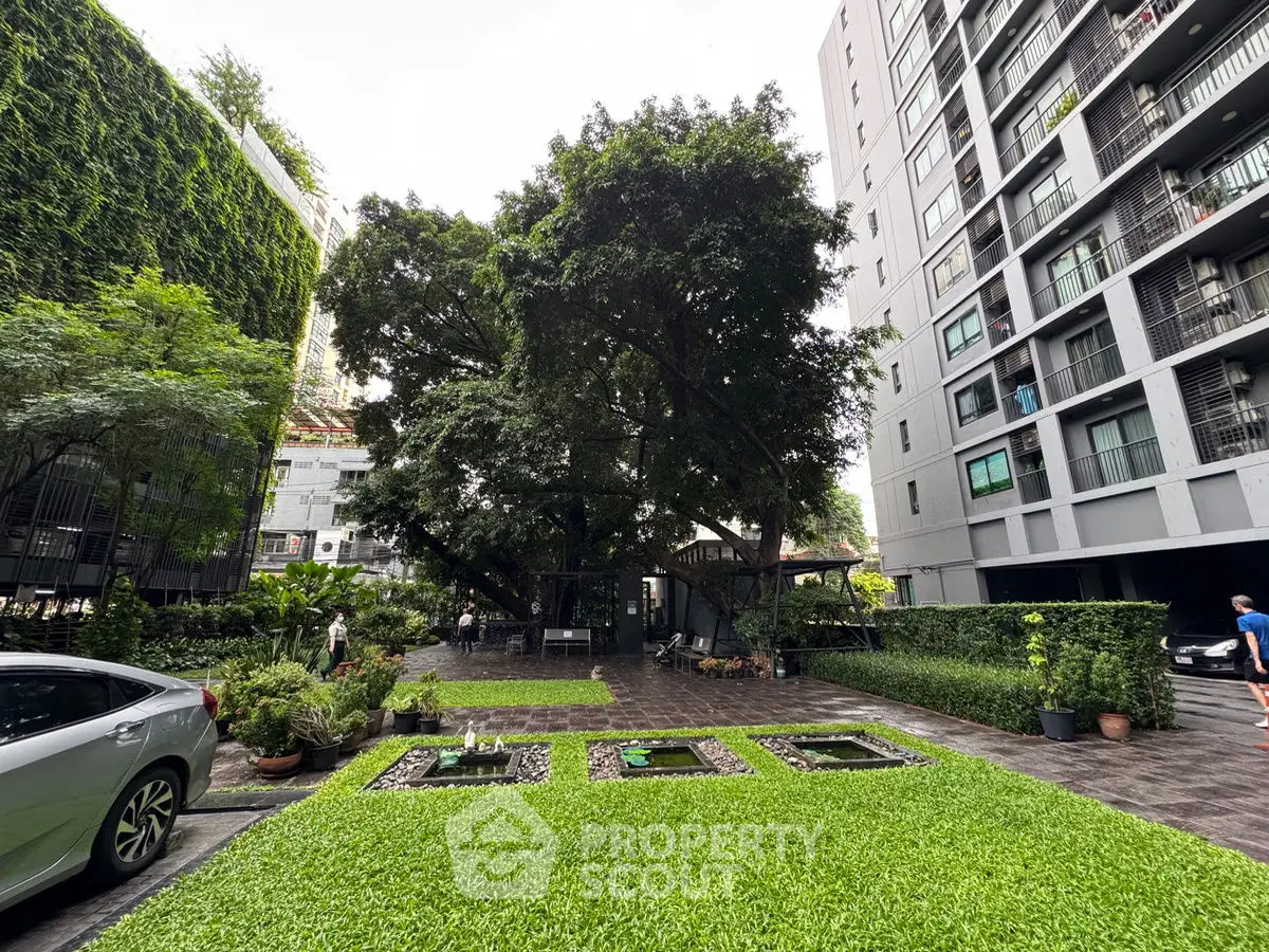 Modern urban garden with lush greenery and high-rise buildings, perfect for city living.