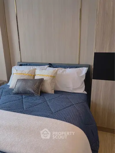 Modern bedroom with stylish bedding and wooden accents, perfect for a cozy retreat.