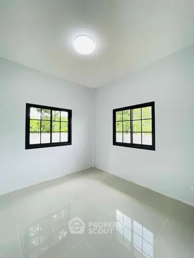Bright empty room with large windows and glossy tiled floor