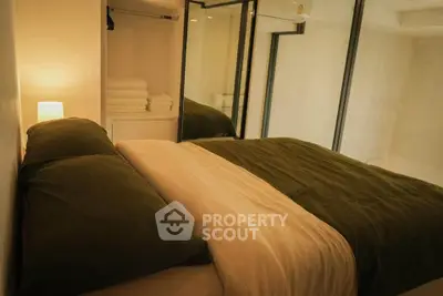 Cozy bedroom with modern design and warm lighting, featuring a comfortable bed and ample closet space.