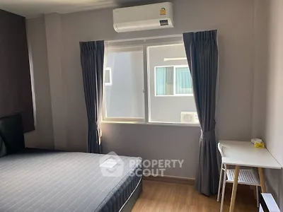 Modern bedroom with natural light, air conditioning, and minimalist decor.