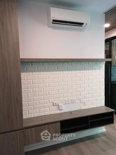 Modern living room with sleek wooden cabinetry and white brick accent wall