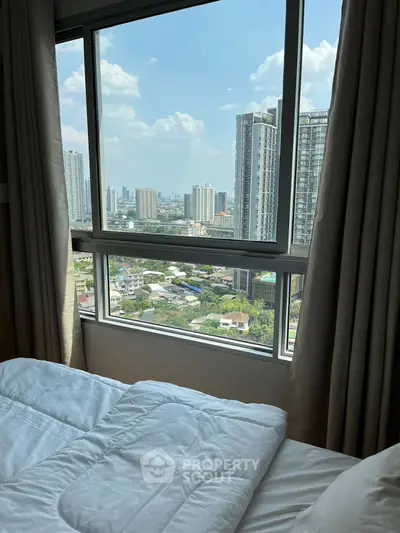 Stunning city view from a cozy bedroom window in a high-rise apartment.