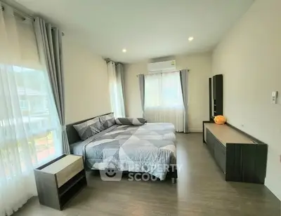 Spacious modern bedroom with large windows and stylish furnishings