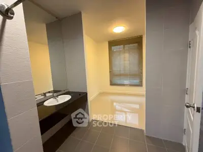 Spacious bathroom with modern fixtures and large window for natural light.