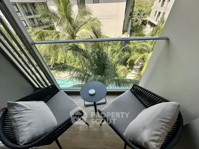 Charming balcony with cozy seating and lush garden view, perfect for relaxation.