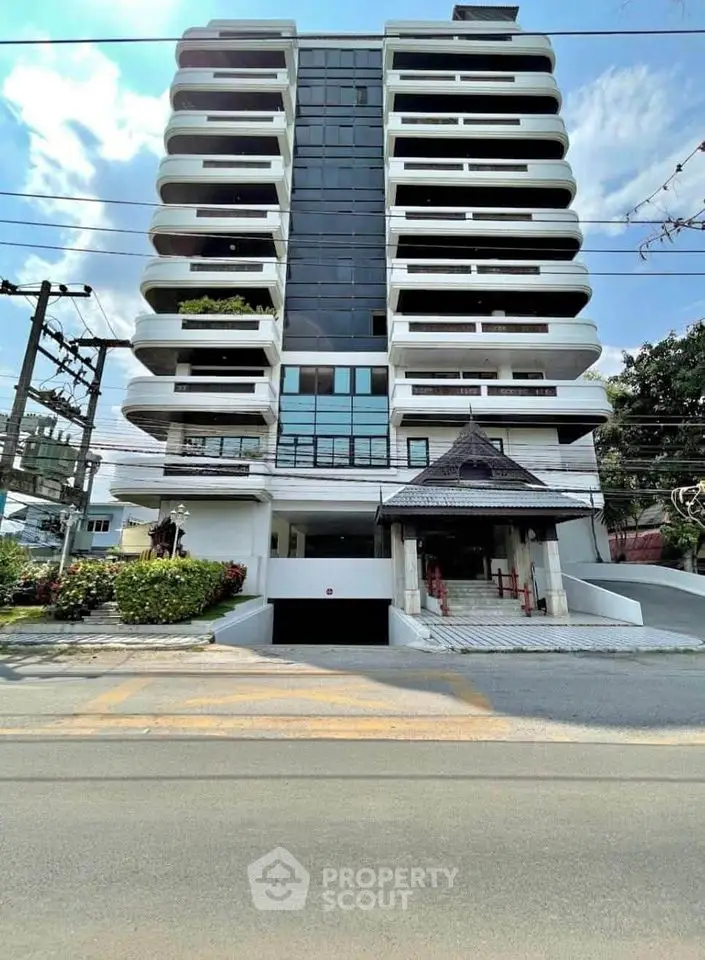 Modern multi-story building with unique architectural design and spacious balconies.