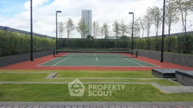 Luxurious outdoor tennis court with lush greenery and modern design.