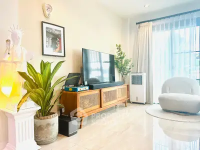 Stylish living room with modern decor and large TV, perfect for relaxation.