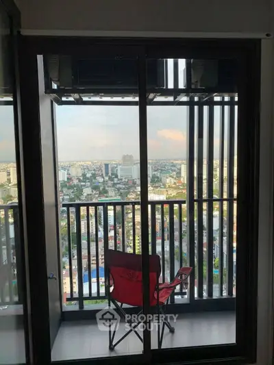 Stunning city view from high-rise balcony with cozy seating, perfect for relaxation and enjoying urban skyline.