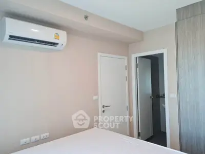 Modern bedroom with air conditioning and ensuite bathroom in a stylish apartment.
