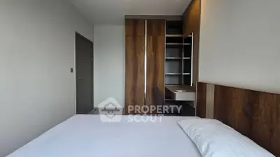 Modern bedroom with sleek wooden wardrobe and cozy bed in a stylish apartment.