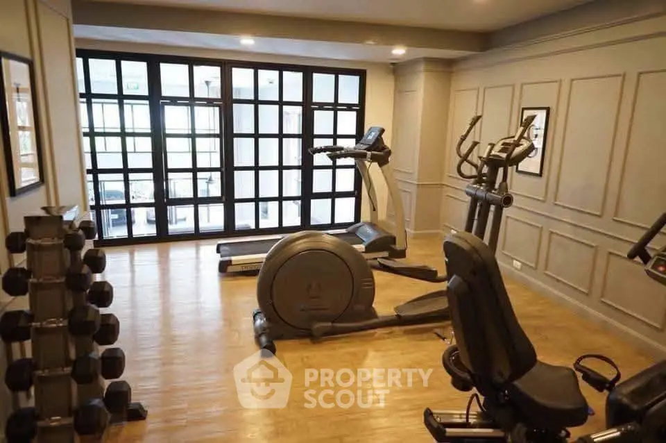 Spacious home gym with modern exercise equipment and wooden flooring