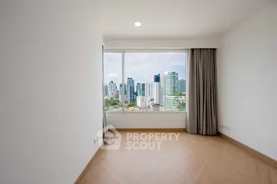 Spacious room with stunning city skyline view through large window.