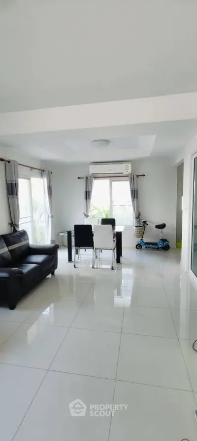 Spacious modern living room with sleek furniture and large windows.