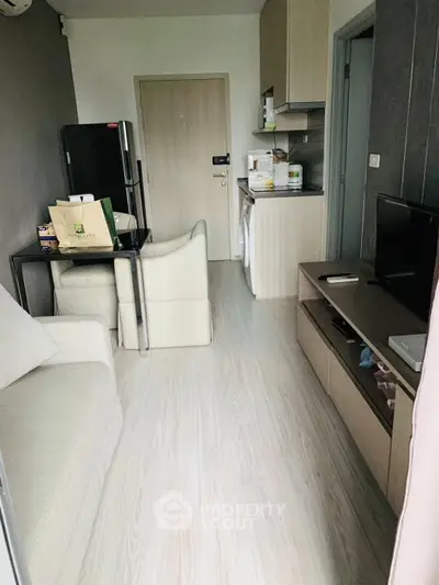Modern compact living room with open kitchen and sleek furniture