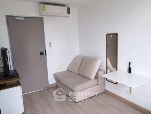 Cozy living room with modern sofa and wall-mounted table in a compact apartment.