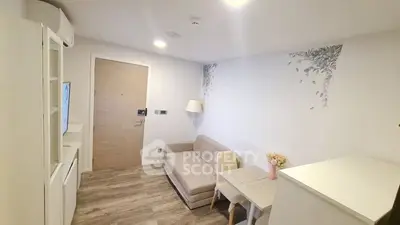Modern minimalist studio apartment with sleek white furnishings, wood flooring, and tasteful wall art, perfect for urban living.