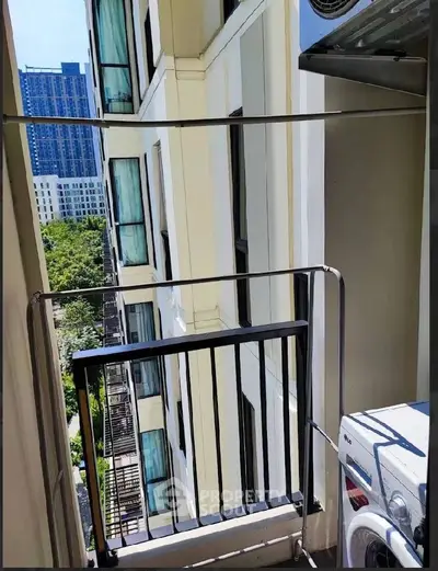 Charming balcony with washing machine and city view in modern apartment building.