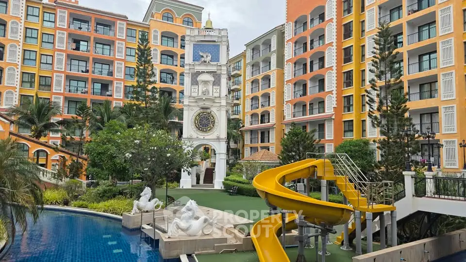 Vibrant apartment complex with pool and slide, lush greenery, and unique architectural design.