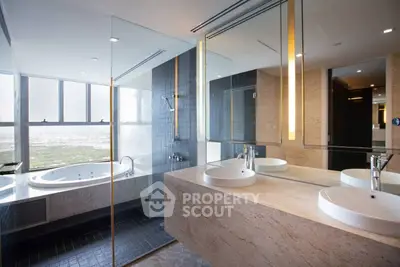 Luxurious modern bathroom with glass shower and large bathtub offering stunning views.