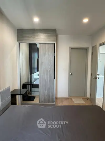 Modern bedroom with sleek wardrobe and neutral decor in a stylish apartment.