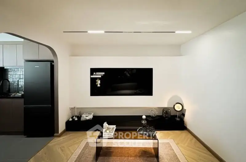 Modern living room with sleek TV setup and stylish decor in a contemporary apartment.