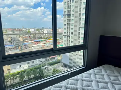 Stunning city view from a modern high-rise apartment bedroom window, showcasing urban living at its finest.