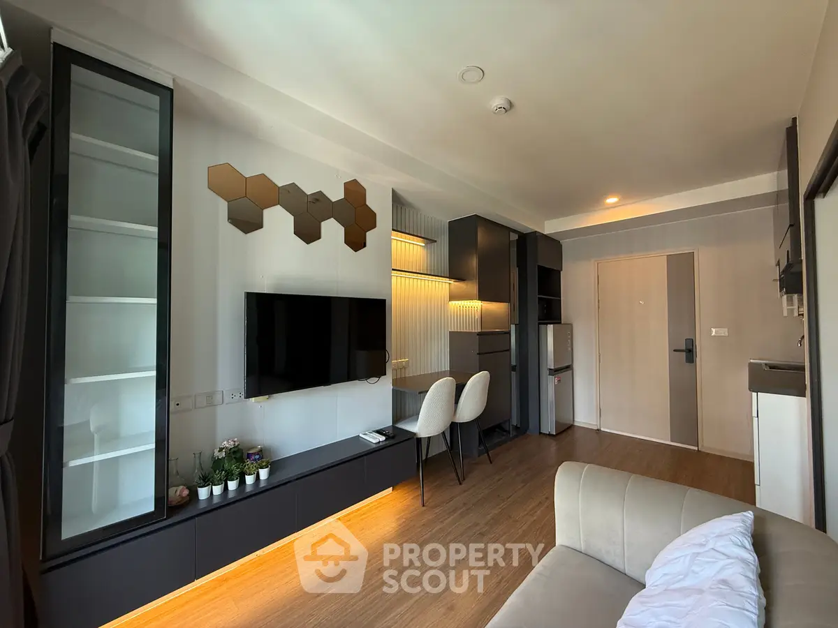 Modern living room with stylish decor and open layout, featuring a wall-mounted TV and sleek furniture.