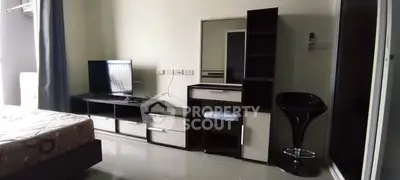 Modern bedroom with sleek furniture and TV setup, ideal for urban living.