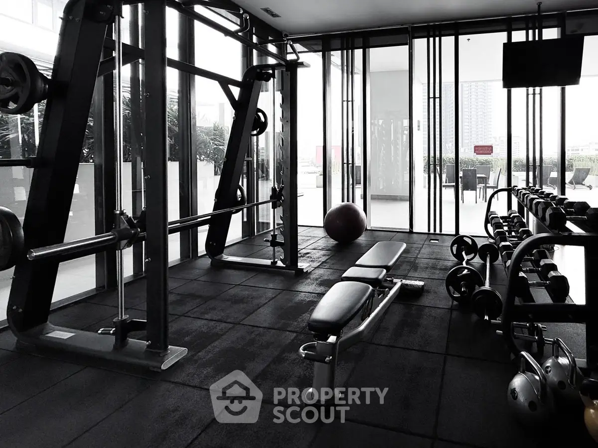 Modern gym with state-of-the-art equipment and city view, perfect for fitness enthusiasts.