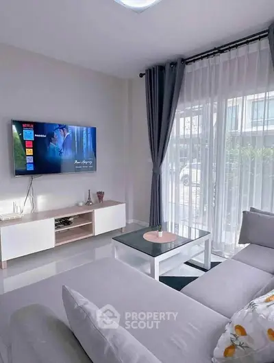 Modern living room with sleek furniture and large window for natural light.