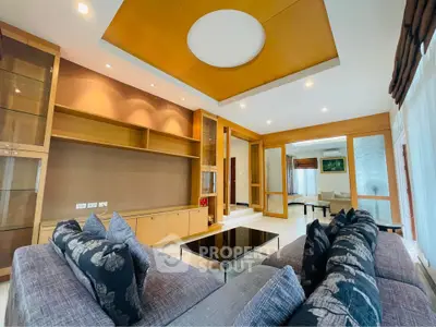 Luxurious living room with modern design, featuring plush sofas and elegant ceiling details.