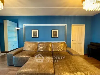 Spacious living room with elegant blue walls and luxurious leather sofa.