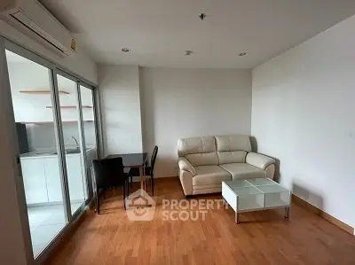 Modern living room with wooden flooring and cozy furniture in open layout apartment.