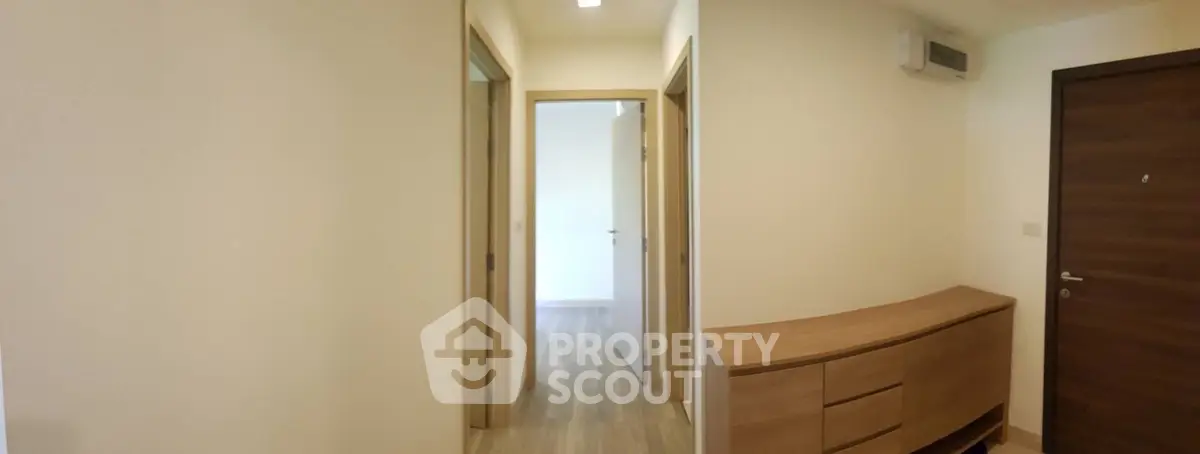 Spacious hallway with modern wooden flooring and stylish storage unit.