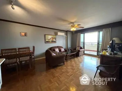 Spacious living room with parquet flooring and balcony access