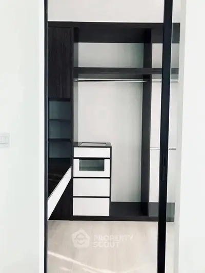 Spacious modern walk-in closet with sleek black and white design