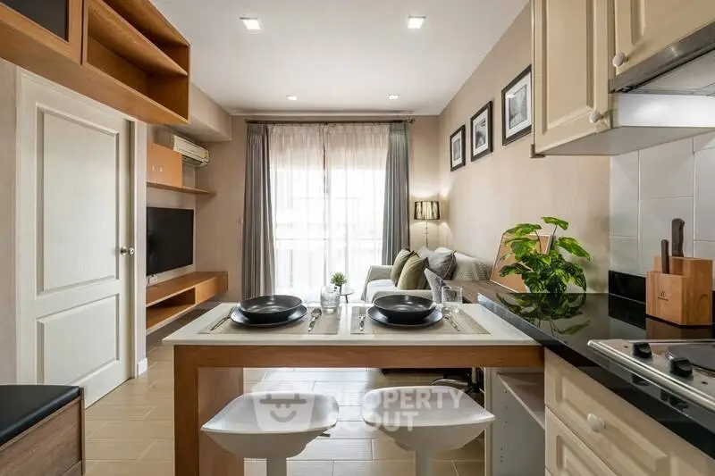Modern open-layout kitchen and living room with stylish decor and natural light.