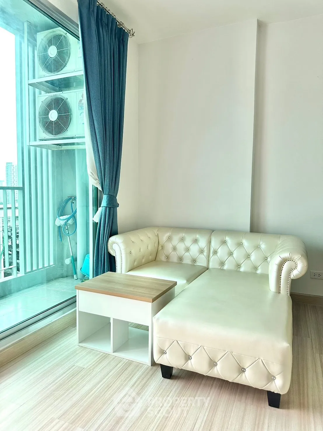 Modern living room with elegant white leather sofa and large window view.