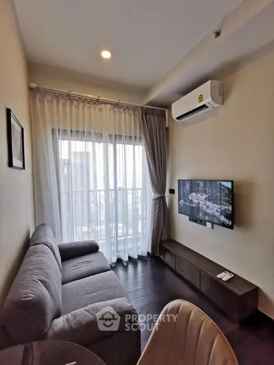 Modern living room with city view, featuring a cozy sofa and wall-mounted TV.