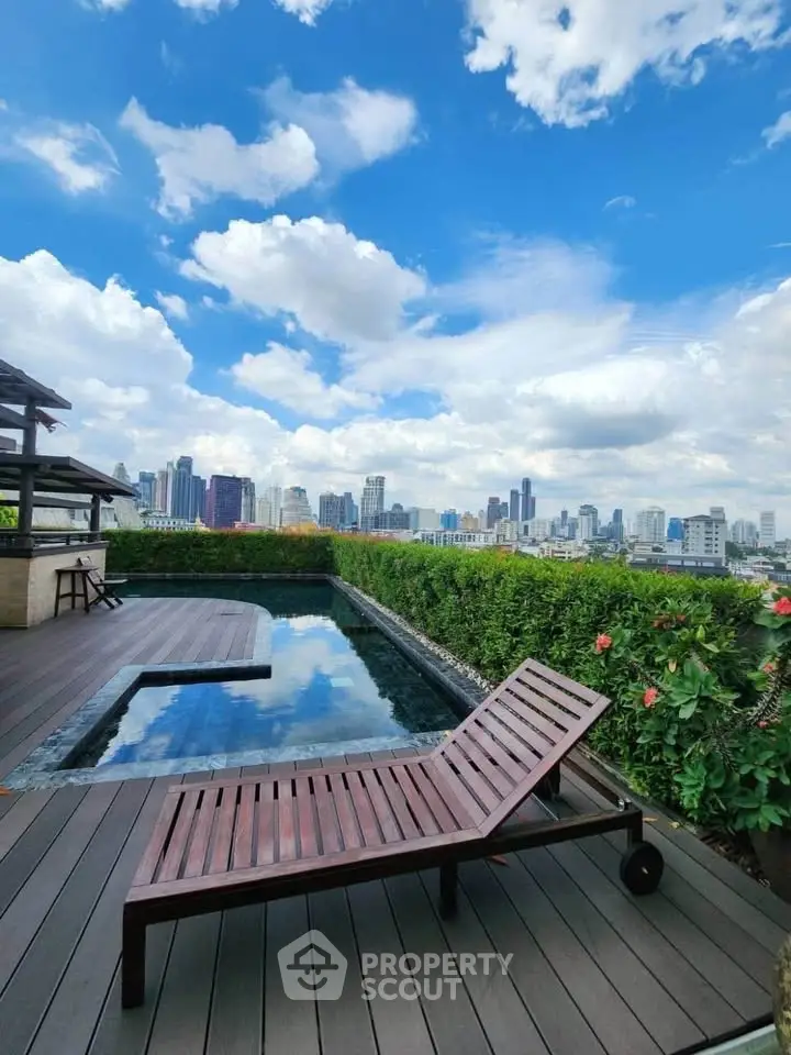 Luxurious rooftop pool with stunning city skyline view and wooden deck seating.