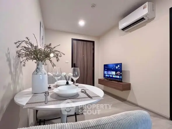 Modern living room with dining area, featuring air conditioning and a wall-mounted TV for cozy urban living.