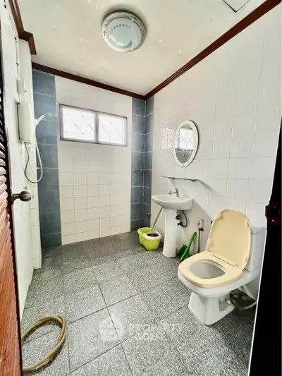 Spacious bathroom with shower and modern fixtures in a well-lit setting.
