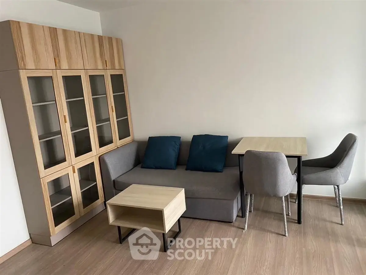 Modern living room with sleek furniture and wooden flooring, perfect for cozy urban living.